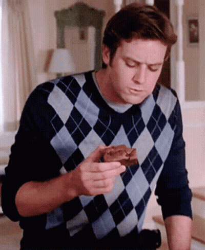 A Man In A Plaid Sweater Is Eating A Piece Of Chocolate Cake GIF