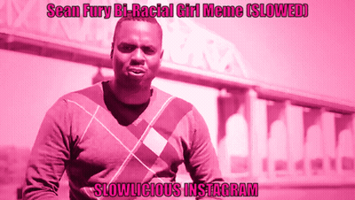 A Man In A Plaid Sweater Stands In Front Of A Pink Background That Says Slowlicious Instagram On It GIF