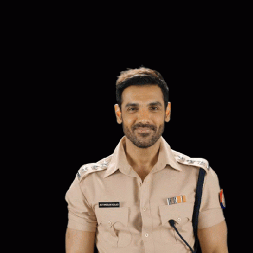 A Man In A Police Uniform Flexes His Muscles And Has A Name Tag On His Chest That Says S.p. Singh GIF