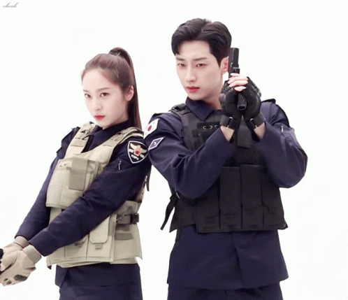 A Man In A Police Uniform Holds A Gun Next To A Woman In A Police Uniform GIF
