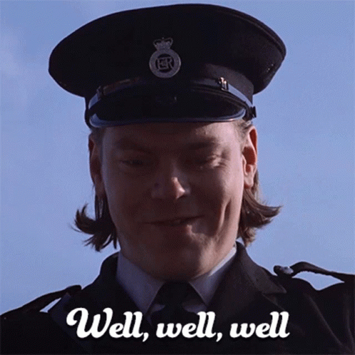 A Man In A Police Uniform Is Smiling With The Words Well Well Well Behind Him GIF