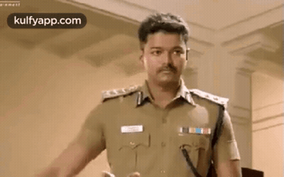 A Man In A Police Uniform Is Standing In A Room And Talking To Someone . GIF
