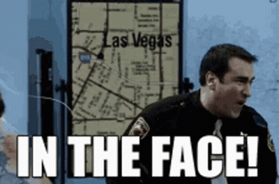 A Man In A Police Uniform Is Standing In Front Of A Map Of Las Vegas . GIF