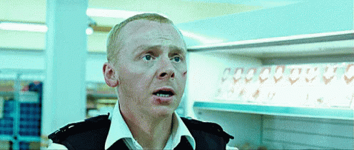A Man In A Police Uniform Is Standing In Front Of A Row Of Empty Shelves GIF