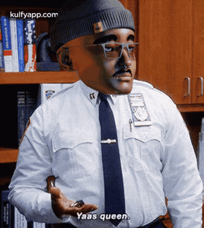 A Man In A Police Uniform Says Yaas Queen While Holding Something In His Hand GIF