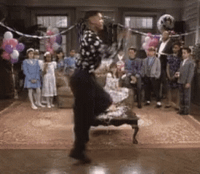A Man In A Polka Dot Shirt Is Dancing In Front Of A Crowd GIF