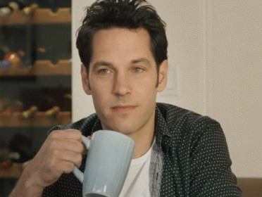 A Man In A Polka Dot Shirt Is Holding A Blue Coffee Mug GIF