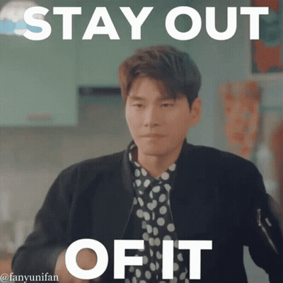 A Man In A Polka Dot Shirt Is Standing In Front Of A Sign That Says " Stay Out Of It " GIF