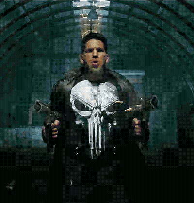 A Man In A Punisher Costume Holds Two Guns GIF