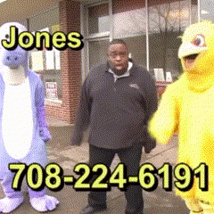 A Man In A Purple Dinosaur Costume Stands Next To A Yellow Duck Costume GIF