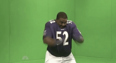 A Man In A Purple Football Uniform Is Dancing In Front Of A Green Screen . GIF