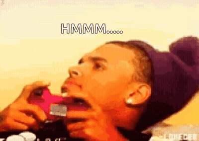 A Man In A Purple Hat Is Taking A Picture With His Mouth Open And The Words Hmmm Written Above Him GIF