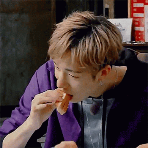 A Man In A Purple Jacket Is Eating A Sandwich With A Fork . GIF