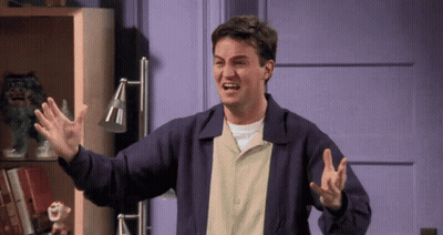 A Man In A Purple Jacket Is Making A Funny Face With His Arms Outstretched GIF