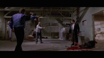 A Man In A Purple Jacket Is Pointing A Gun At Another Man GIF