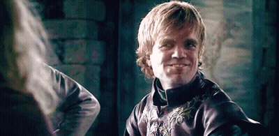 A Man In A Purple Jacket Is Smiling While Looking At Another Man . GIF