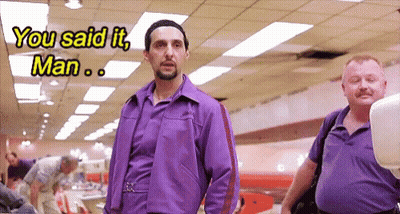 A Man In A Purple Jacket Is Talking To Another Man GIF