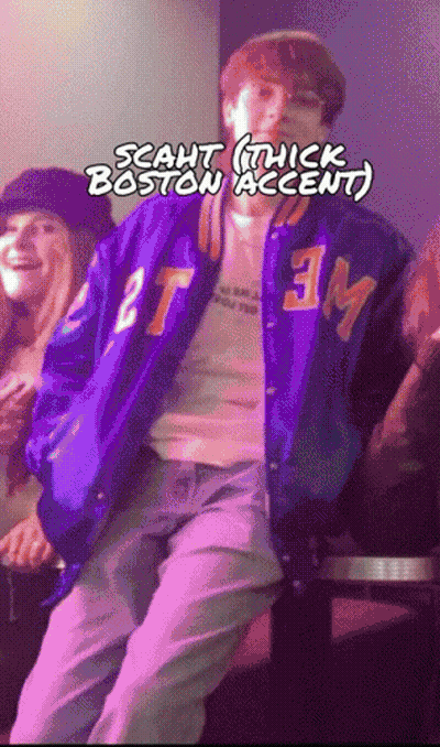 A Man In A Purple Jacket With The Letters Tm On It GIF
