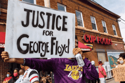 A Man In A Purple Lakers Shirt Holds A Sign That Says Justice For George Floyd GIF