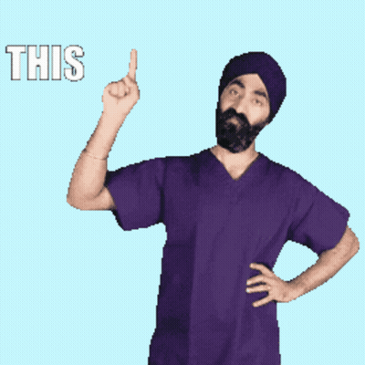 A Man In A Purple Scrub Top Is Pointing Up With The Word This Behind Him GIF