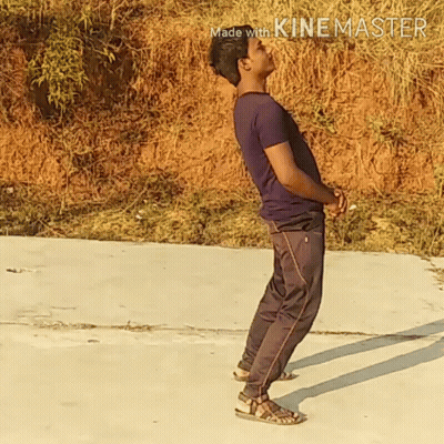A Man In A Purple Shirt And Black Pants Is Standing On A Concrete Surface With The Words Made With Kinemaster In The Cor GIF