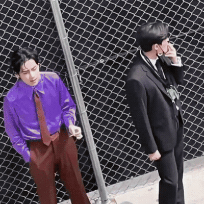 A Man In A Purple Shirt And Tie Is Standing Next To A Man In A Black Suit . GIF
