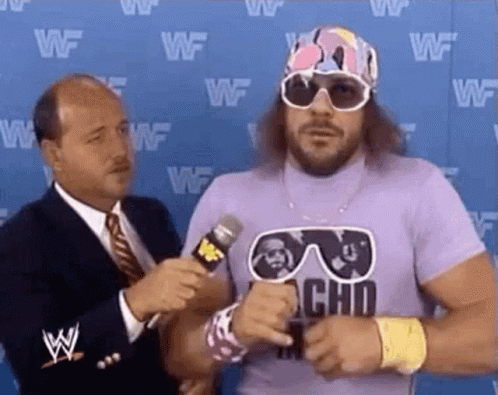 A Man In A Purple Shirt Is Being Interviewed By A Man In A Suit And Tie . GIF