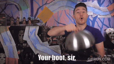 A Man In A Purple Shirt Is Holding A Metal Object And Says " Your Boot Sir " GIF