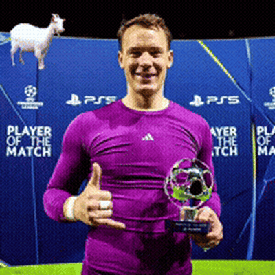 A Man In A Purple Shirt Is Holding A Trophy And Giving A Thumbs Up Sign GIF