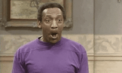 A Man In A Purple Shirt Is Making A Surprised Face In Front Of A Painting . GIF