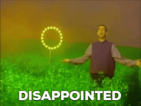 A Man In A Purple Shirt Is Standing In A Field With The Word Disappointed Written On The Bottom . GIF