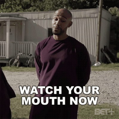 A Man In A Purple Shirt Is Standing In Front Of A Trailer And Says Watch Your Mouth Now GIF