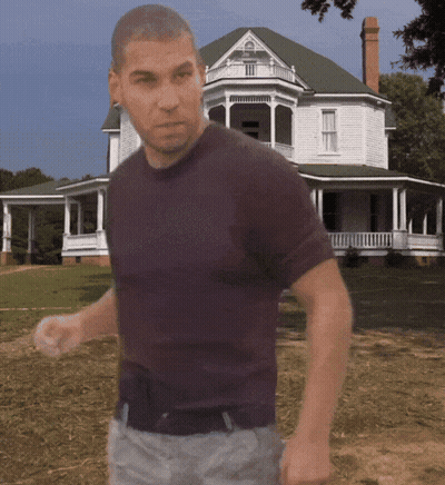 A Man In A Purple Shirt Is Standing In Front Of A White House GIF