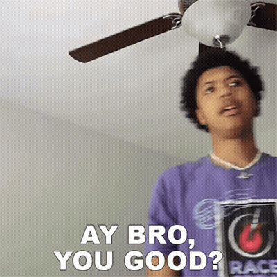 A Man In A Purple Shirt Is Standing Under A Ceiling Fan And Saying " Ay Bro You Good " GIF