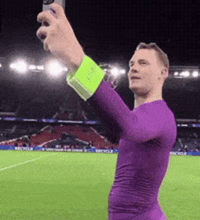 A Man In A Purple Shirt Is Taking A Picture Of Himself GIF