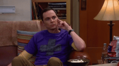 A Man In A Purple Shirt Sits On A Couch With A Bowl Of Popcorn GIF
