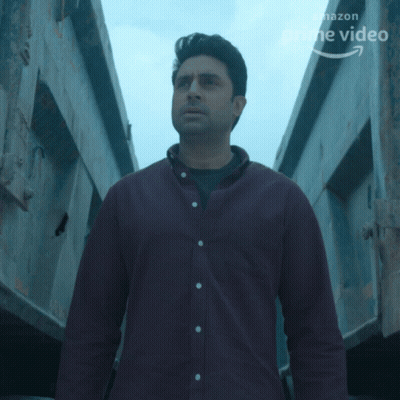 A Man In A Purple Shirt Stands In Front Of A Sign That Says Prime Video GIF