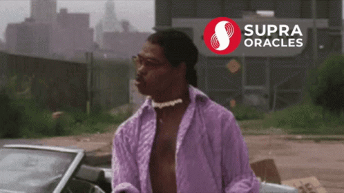 A Man In A Purple Shirt Stands In Front Of A Supra Oracles Sign GIF