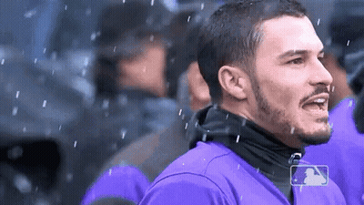 A Man In A Purple Shirt With A Mlb Logo On His Shirt GIF