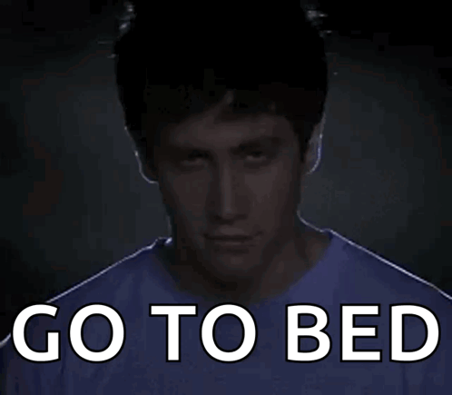 A Man In A Purple Shirt With The Words Go To Bed Written On It GIF