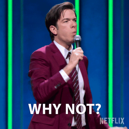 A Man In A Purple Suit And Tie Is Holding A Microphone And Says Why Not GIF