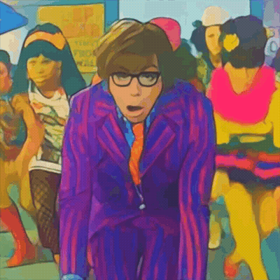 A Man In A Purple Suit And Tie Stands In Front Of A Crowd Of People GIF