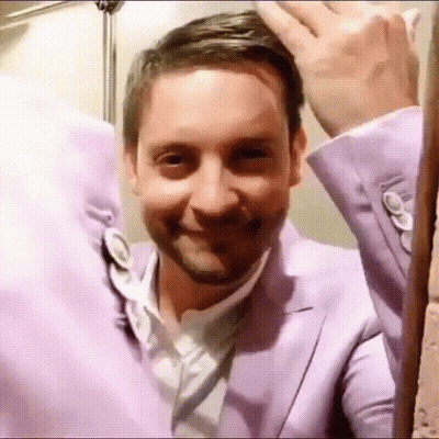 A Man In A Purple Suit And White Shirt Is Smiling GIF