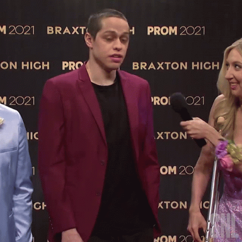 A Man In A Purple Suit Is Being Interviewed By A Woman And The Words Uh Yeah Are Visible GIF