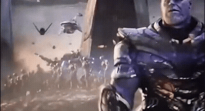 A Man In A Purple Suit Is Standing In Front Of A Crowd Of People With Planes Flying In The Background GIF