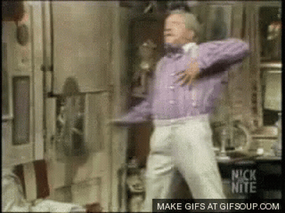 A Man In A Purple Sweater And White Pants Is Dancing In A Room With A Nick Nite Logo In The Corner GIF