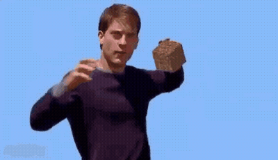 A Man In A Purple Sweater Is Holding A Large Rock In His Hand . GIF