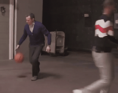 A Man In A Purple Sweater Is Running With A Basketball In His Hands . GIF