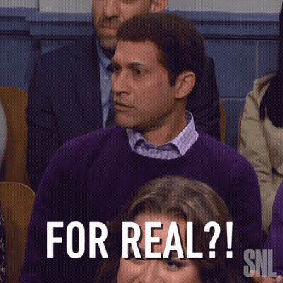 A Man In A Purple Sweater Sits In Front Of A Sign That Says " What The Hell Is That Snl " GIF