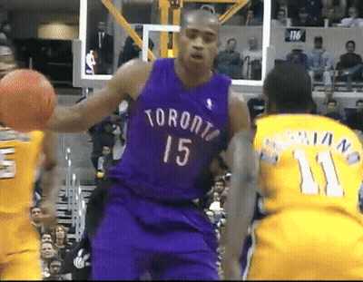 A Man In A Purple Toronto Jersey Holds A Basketball GIF